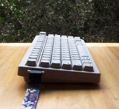 Teclado mecánico MyKeyboard CIDOO QK75 gris de formato 75% con perilla de volumen y correa decorativa sobre mesa de madera