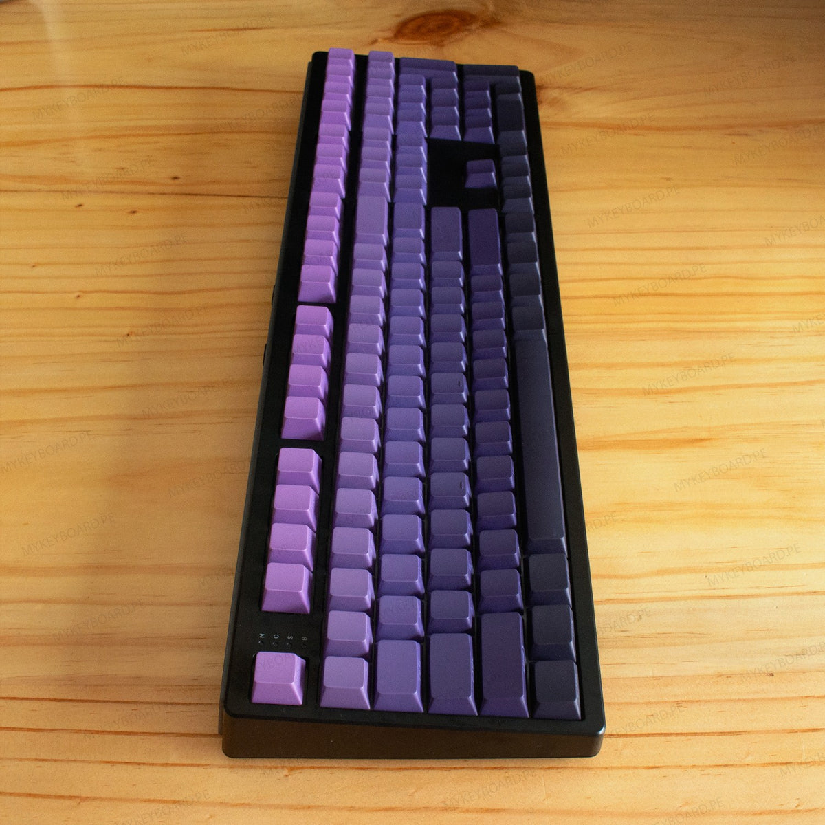Teclado mecánico MyKeyboard EPOMAKER TH108 con teclas en degradado de morado a violeta sobre superficie de madera
