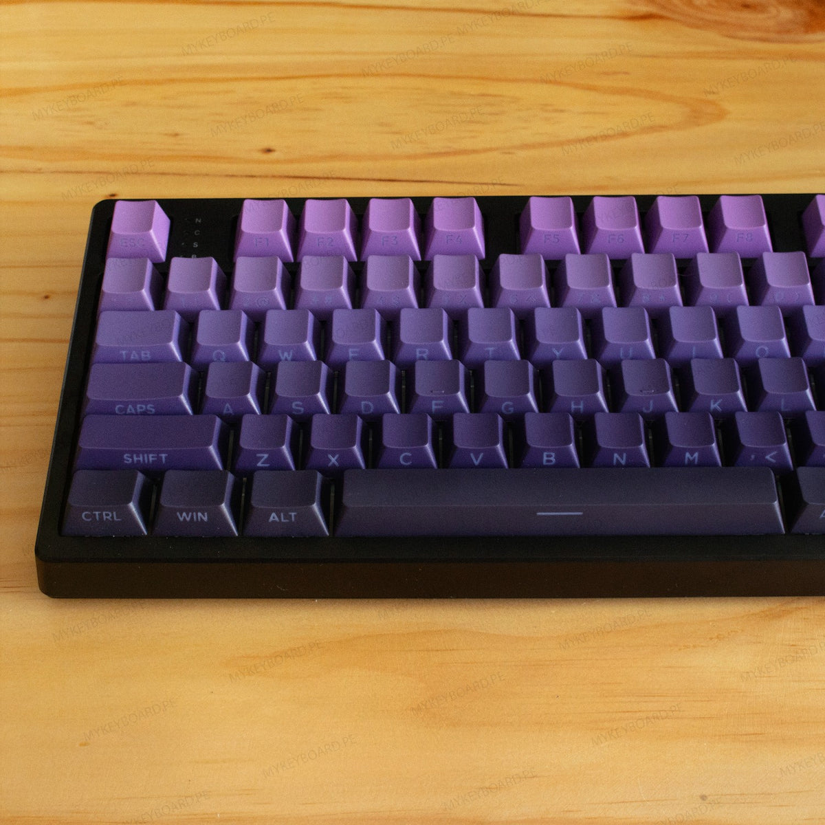 Teclado mecánico MyKeyboard EPOMAKER TH108 con teclas en degradado morado y base negra sobre superficie de madera.