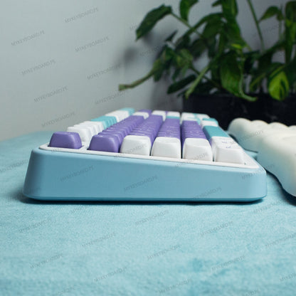 Teclado mecánico MyKeyboard Epomaker TH99 Mulan con teclas moradas y blancas y base azul claro en vista lateral