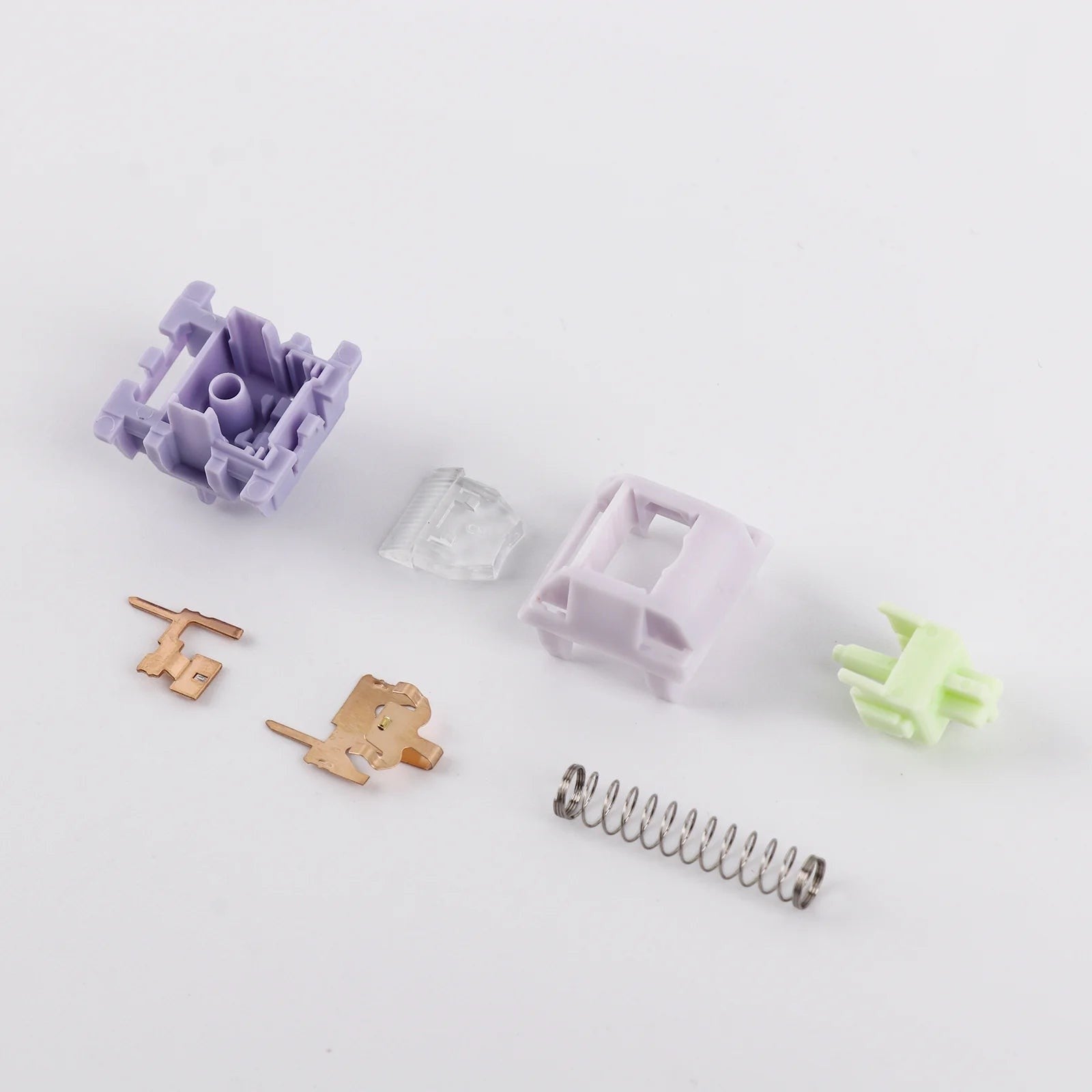 Componentes desmontados del switch lineal MyKeyboard EPOMAKER Wisteria V2 en tonos lila, verde y metal