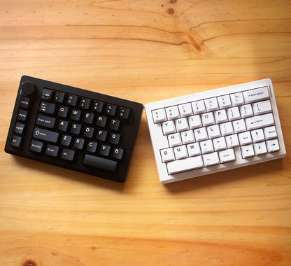 Teclado mecánico dividido MyKeyboard Epomaker Split 70 en blanco y negro con perilla de volumen sobre mesa de madera