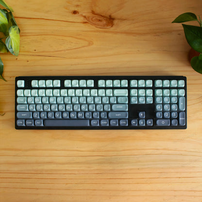 Teclado mecánico MyKeyboard EPOMAKER TH108 con teclas en degradado verde sobre escritorio de madera