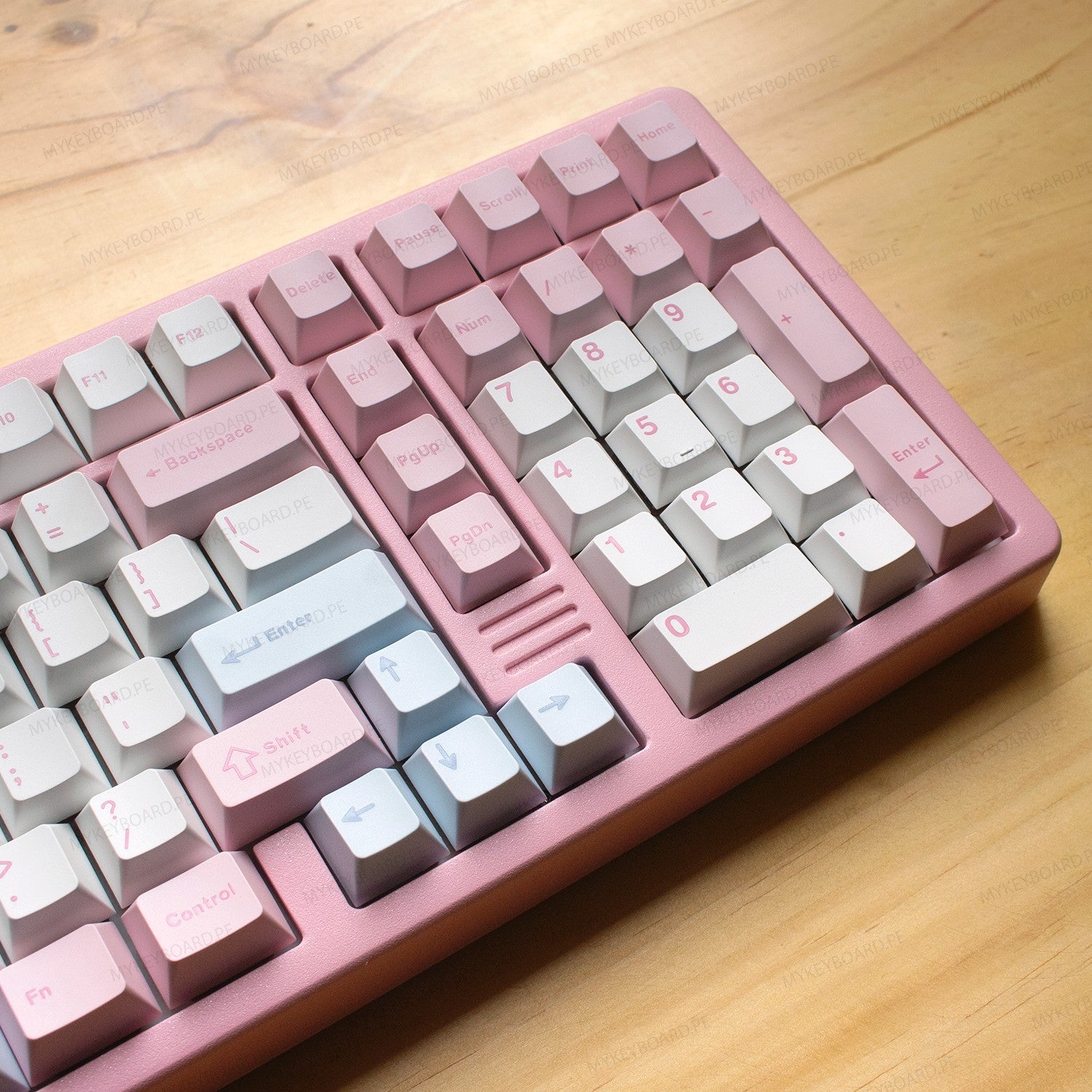 Teclado mecánico MyKeyboard YUNZII AL98 rosa con formato 98%, teclas PBT y cuerpo de aluminio sobre mesa de madera.